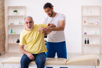 Fototapeta premium Old male patient visiting young male doctor chiropractor