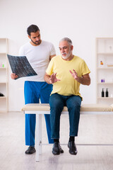 Fototapeta na wymiar Old male patient visiting young male doctor chiropractor