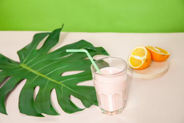 Tasty smoothie in glass on table on green background