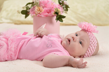 cute little baby girl  on bed with flowers