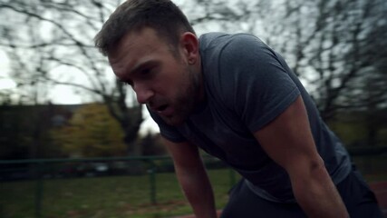 Caucasian male athlete running on tracking field checking watch 