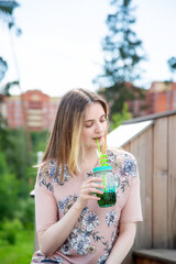 A young girl enjoys the sun and weather while sitting on a wooden podium