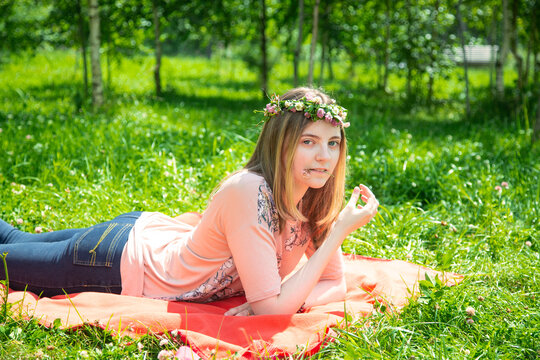 Young girl smiling looking at the camera while lying on the lawn in the park