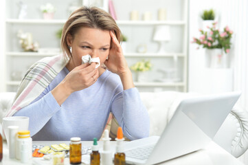 beautiful young woman with pills using laptop