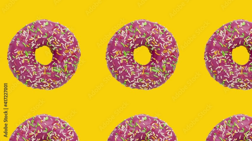 Poster pink rotating donuts in geometric pattern on a yellow background. minimal motion graphics food conce