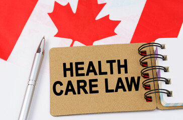 Against the background of the flag of Canada lies a notebook with the inscription - HEALTH CARE LAW