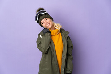 Skier Russian girl with snowboarding glasses isolated on purple background laughing