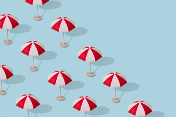 Creative idea, a pattern of colorful umbrellas on a light blue background.