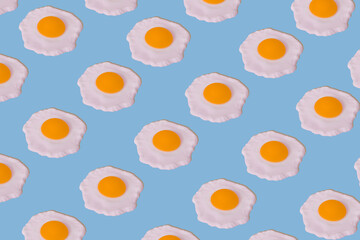 Food pattern of fried eggs on bright blue background