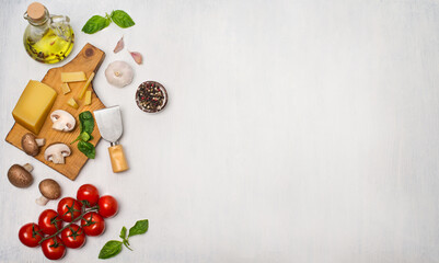 Cherry tomatoes mushrooms pasta basil leaves and parmesan top view with copy space. Italian and Mediterranean food ingredients on white wooden background. 