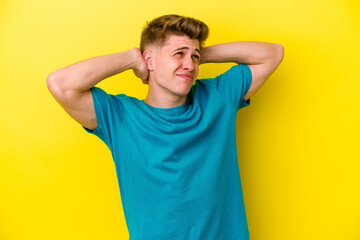 Fototapeta na wymiar Young caucasian man isolated on yellow background suffering neck pain due to sedentary lifestyle.