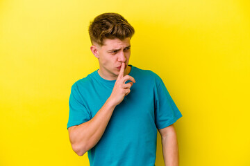 Young caucasian man isolated on yellow background keeping a secret or asking for silence.
