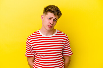 Obraz premium Young caucasian man isolated on yellow background sad, serious face, feeling miserable and displeased.