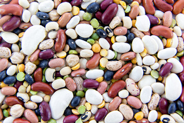 Assorted dried beans scattered on a surface