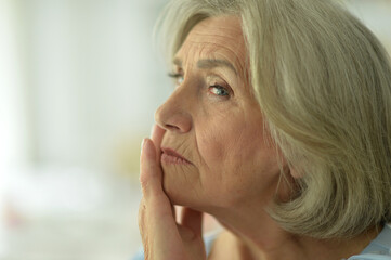 Close up portrait of sad senior woman at home