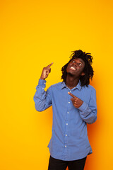 young handsome african american guy student posing cheerful and gesturing on yellow background, lifestyle people concept