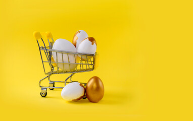 Mock up Easter composition with shopping trolley and  golden decorated eggs on yellow background....
