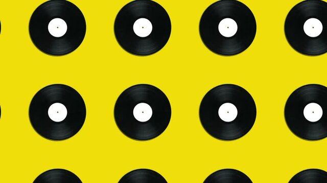 Yellow background with vintage vinyl disks in geometric pattern. Minimal motion graphics music looped animated concept