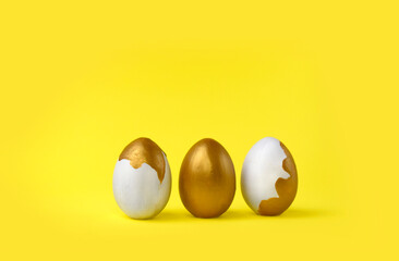Minimalist Easter composition. Golden decorated eggs in row on yellow background. Trendy color concept. Happy Easter greeting card with copyspace.