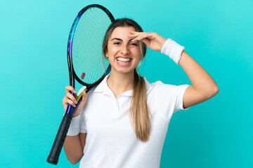 Young caucasian woman isolated on blue background playing tennis