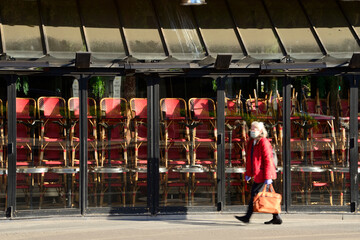 Une personne portant un masque marche devant un restaurant fermé pour cause de coronavirus à...