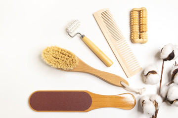 Fototapeta premium Natural wooden bath accessories for care, massage brush, hair comb, massagers, pedicure file on a light background, top view. Plastic-free, eco-friendly life.