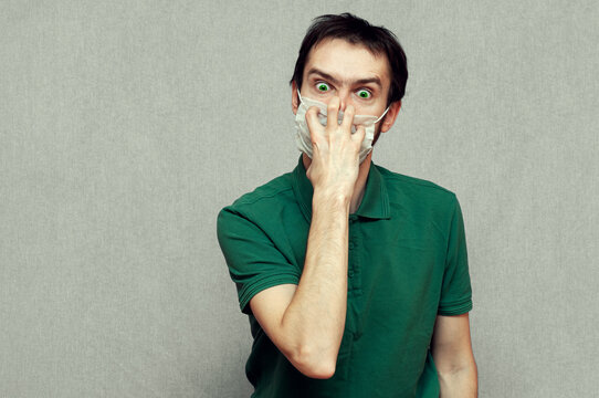 man in panic trying tear off a medical mask. virus mutation, panic, paranoia
