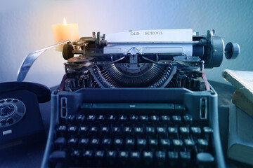 typewriter on table, words fake news are printed on paper in large size, candle is burning, retro...