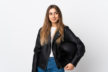 Young Woman holding a motorcycle helmet over isolated white background standing and looking to the side