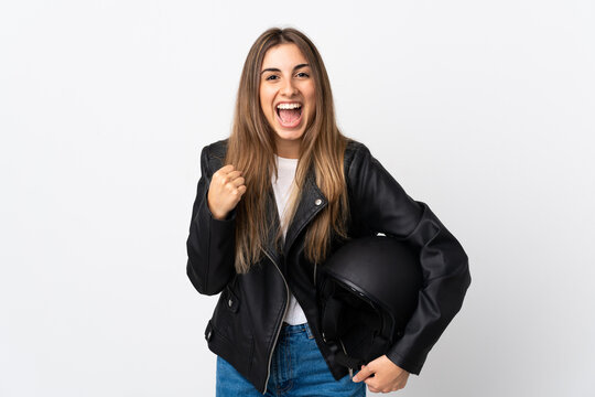 Young Woman holding a motorcycle helmet over isolated white background celebrating a victory