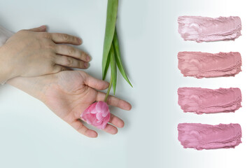 close-up of the hand of a young woman, female, holding a spring flower, pink tulip, the concept of awakening nature, aroma of plants, cosmetology and skin care