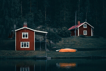 Moody dark swedish houses on a lake at the water