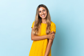 Young hispanic woman over isolated blue background laughing