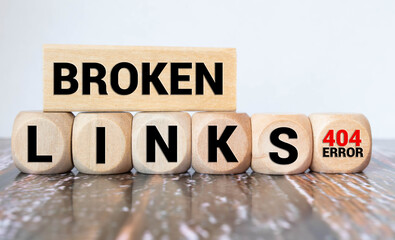 Broken links - text concept website on a wooden background surrounded by cubes.