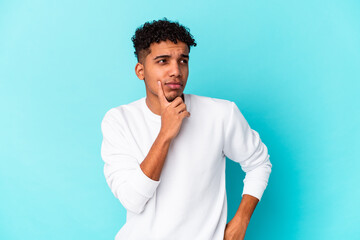 Young african american curly man isolated on blue contemplating, planning a strategy, thinking about the way of a business.