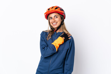 Young hispanic cyclist woman isolated on white background looking up while smiling