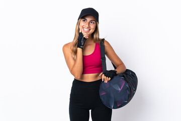 Young sport woman with sport bag over isolated white background thinking an idea while looking up