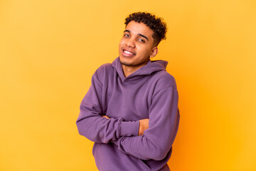 Young african american curly man isolated on purple who feels confident, crossing arms with determination.