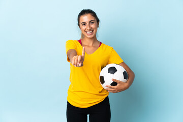 Young hispanic football player woman over isolated on blue background showing and lifting a finger