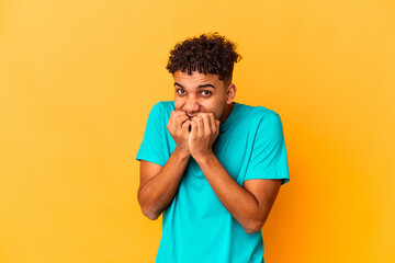 Young african american curly man isolated on purple biting fingernails, nervous and very anxious.