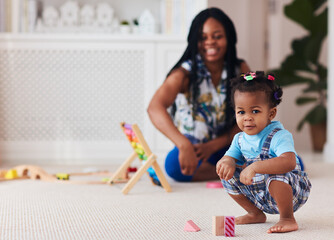 happy toddler baby girl playing toys with mother at home