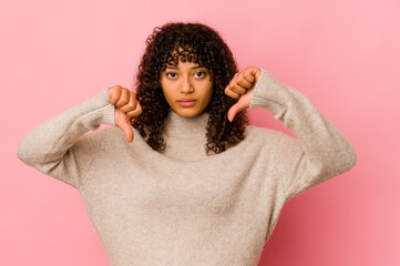 Young african american afro woman isolated showing a dislike gesture, thumbs down. Disagreement...
