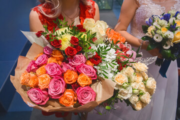Witness young girl holds huge bouquets of wedding flowers roses close up