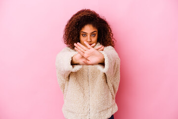 Young african american woman isolated on pink background doing a denial gesture