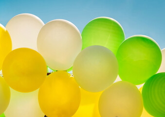Colorful bright balloons against the blue sky close-up