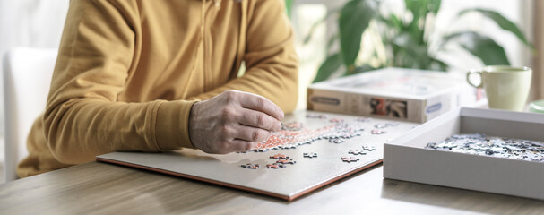 Man solving a puzzle at home