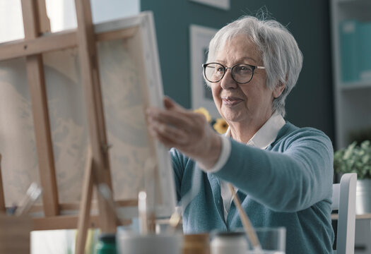 Happy Senior Lady Looking At Her Finished Artwork