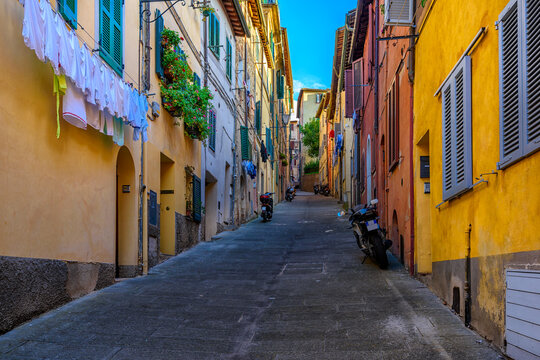 Fototapeta Medieval narrow street in Siena, Tuscany, Italy. Architecture and landmark of Siena. Cozy cityscape of Siena