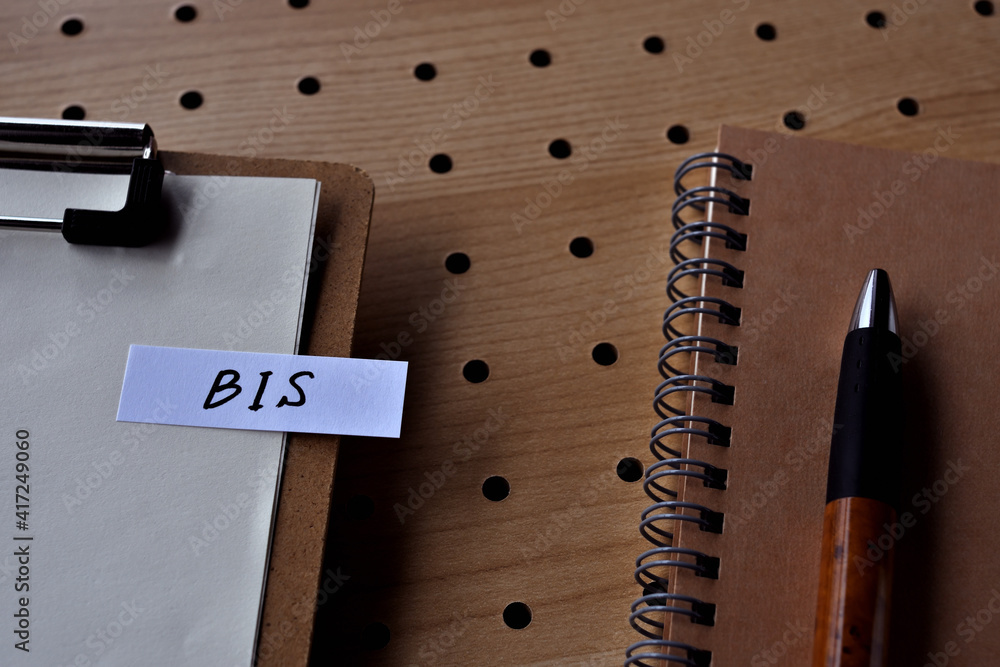 Poster on the desk there is a notebook, and a stickynote with the word bis written on it. it was an abbrevi