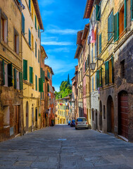 Fototapeta na wymiar Medieval narrow street in Siena, Tuscany, Italy. Architecture and landmark of Siena. Cozy cityscape of Siena
